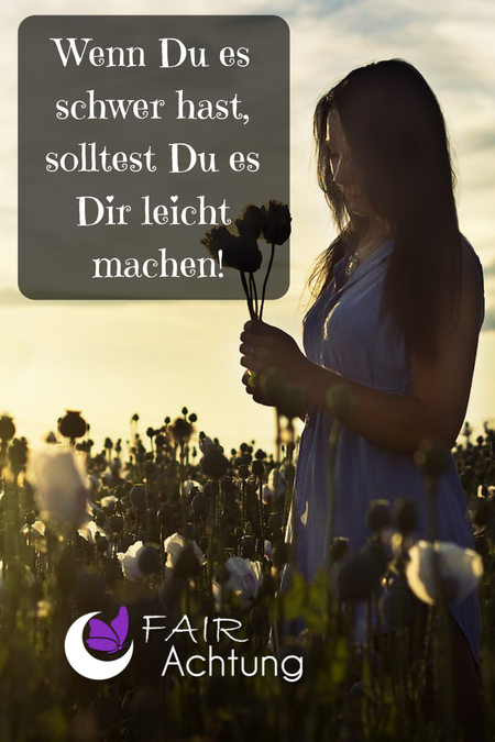 Eine Frau steht im Wildblumenbeet und hat einige gepflückte Blumen in den Händen. Sie wirkt in sich gekehrt. Dort steht "Wenn Du es schwer hast, solltest Du es Dir leicht machen."