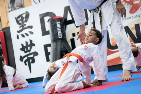 Mädchen auf dem Bild. Das Mädchen macht das Stop zeichen mit der Hand. Sicherheitsteil im Karate. Selbstschutz und Selbstverteidigung.