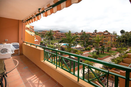 Blick von der Terrasse mit Gartenmöbel in die Grünanlage.