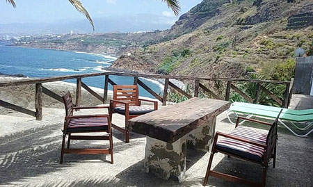 Blick von der Terrasse über  den gepflegten Garten bis zum Meer.
