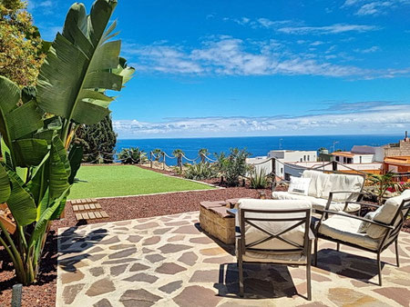 Blick von der Terrasse über  den gepflegten Garten bis zum Meer.
