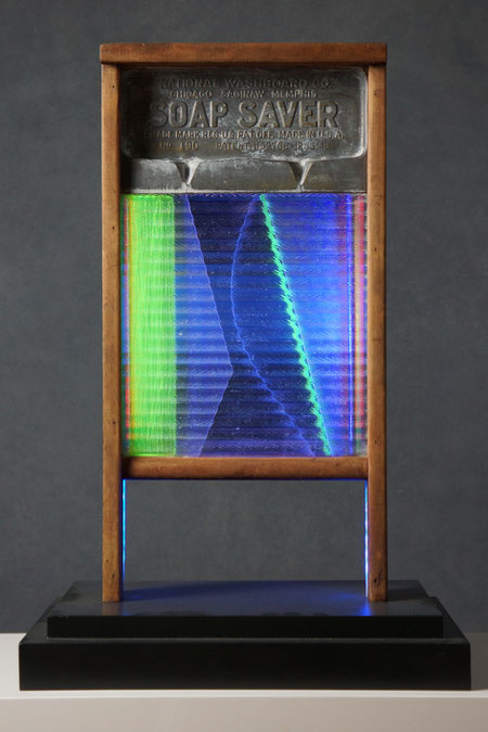 Assemblage light art sculpture made from an old glass washboard. This sculpture acts almost as a "light painting" with plexiglass, lenticular plastic, and LEDs placed in back.  The glass which refracts the light and the appearance of these components.