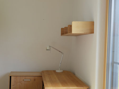 Fertige Lehmwand in einem ruhigen Arbeitsbereich mit Schreibtisch und Fensterlicht