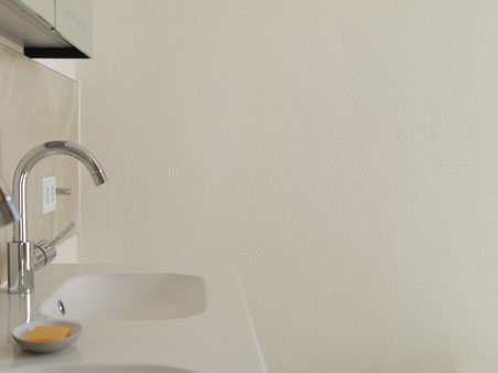 Wand mit Lehmfarbe in Marmorweiß neben dem Waschbecken, außerhalb des direkten Spritzwasserbereichs.