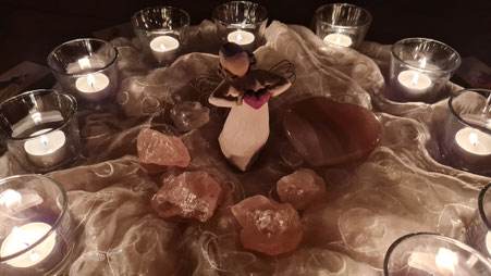 Aufnahme eines Engels, der ein rotes Herz in den Händen hält. Der Engel steht von brennenden Kerzen umgeben. Das Bild steht symbolisch für das Angebot des mentalen Heilkreis für Kinder über die Ferne von Svenja Lampke.