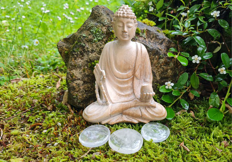 Nahaufnahme eines Buddas auf Moos sitzend mit dem Stein des Monats vor sich liegend. Steht symbolisch für Svenja Lampkes Stein des Monats.