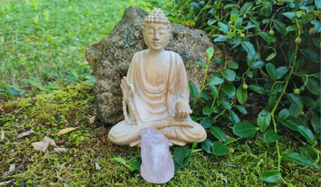 Nahaufnahme eines Buddas auf Moos sitzend mit dem Stein des Monats vor sich liegend. Steht symbolisch für Svenja Lampkes Stein des Monats.
