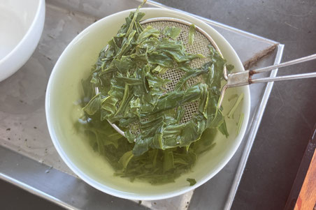 Evaluating the quality of the tea through taste, aroma, and color.