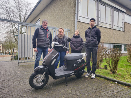 Herr Düpont und Frau Maag vom Förderverein übergeben symbolisch die neue Mofa an die Schülerinnen und Schüler.