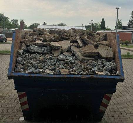 Hamburger Containerdienst bei der Arbeit, beladen mit Steinen. 