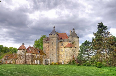 Vue du Château de Villemonteix, Creuse, avec ses tours élégantes et son parc verdoyant.