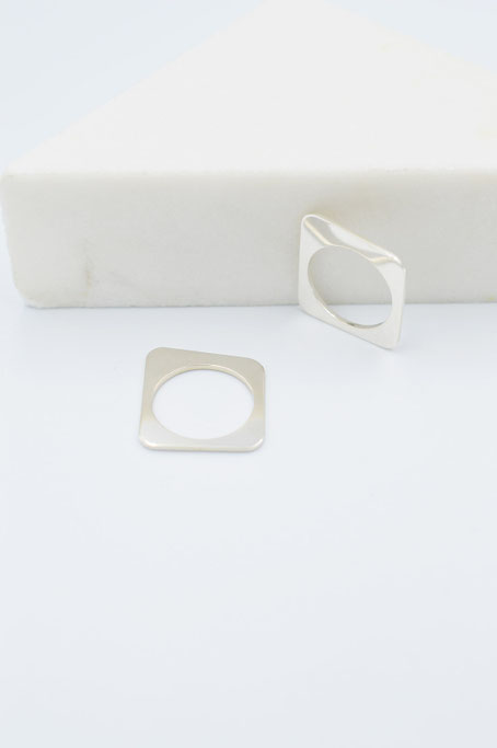 2 bagues géométriques Forma en argent brillant contre du marbre