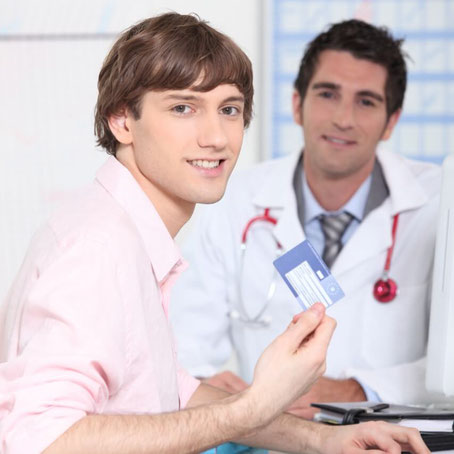Mann mit Versicherungskarte beim Arzt