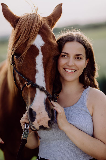 Portrait einer jungen Frau mit einem rotbraunen Pferd