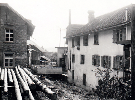 Abb.6: Das Sägerei-Areal mit geschälten Baumstämmen. Rechts der Anbau des Gashaus zur Sonne, dazwischen der Dorfbach. Fotografie aus den 1930er-Jahren.