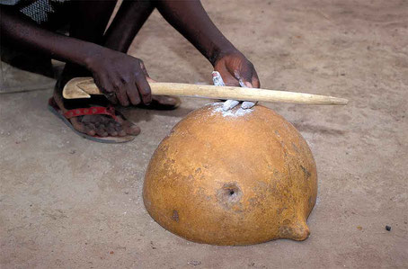 Femme gan frottant son doigt recouvert de cendre sur une calebasse. © P. Kersalé 1999-2024.