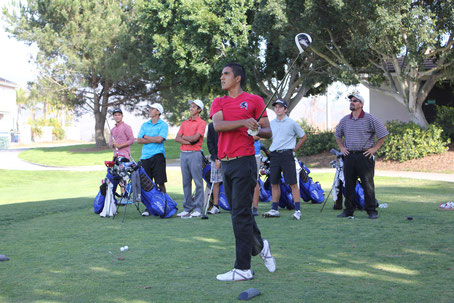 Senior, Alex Valdovinos, admires the flight of his drive as teammates and coach look on.