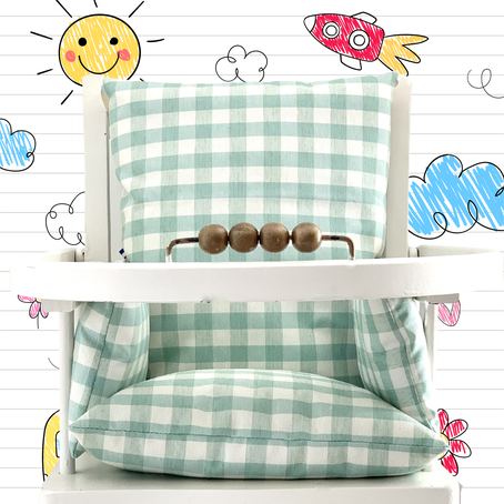Cette image représente le coussin de chaise haute en coton ciré couleur vert d'eau et motif vichy