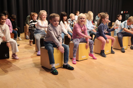 Erstklässler auf der Bühne an den Cajons