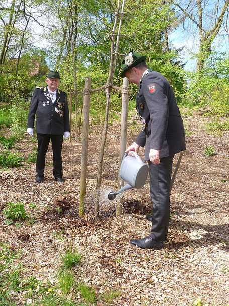 Kommandeur Hans-Hinrich Bruns (li.) überwachte, dass König Michael Schröder den neu gepflanzten Baum sachgerecht wässerte.