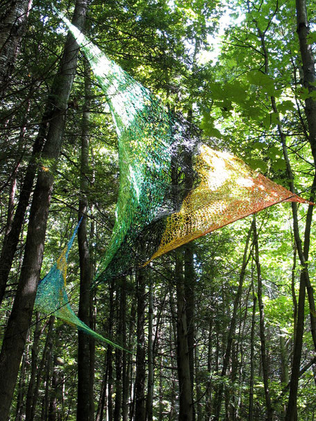 Au sommet de quelqus arbres des triangles de filets de couleurs forment une sculpture biologique.#provence#art#ayniart.
