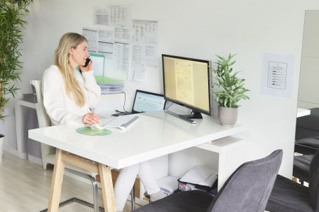 Julia Emberger sitzt im Büro und telefoniert mit einem Kunden
