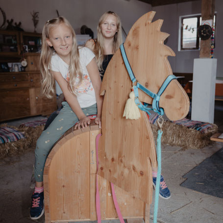 Zwei Kinder auf dem Holzlama in der beheizbaren Scheune