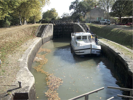 L'écluse double de Laval : le sas d'aval et la porte médiane vus depuis le pont qui suit la porte d'aval. Le sas d'amont est de l'autre côté de cette porte médiane, on voit à sa droite la maison éclusière.