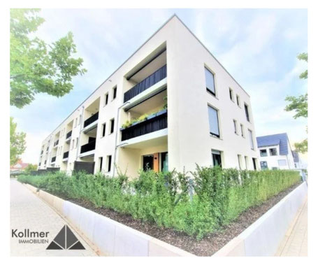 Eine Erdgeschosswohnung in einem beigen Mehrfamilienhaus mit grüner Hecke und Schwarzen Balkongeländer. Dieses Mehrfamilienhaus befindet sich in Herzogenaurach und wird durch Kollmer IMMOBILIEN verkauft. Es ist ein Immobilienangebot.