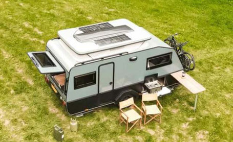 Kleiner grüner Wohnwagen mit Solar auf dem Dach 2026