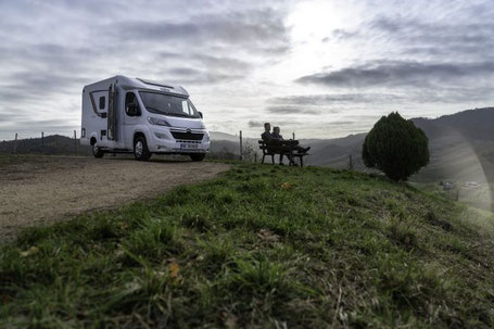 Weißes Teilintegriertes Wohnmobil ist in den Hügeln abgestellt 2026