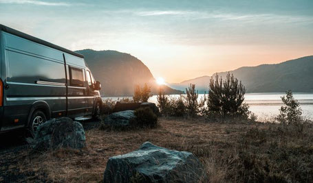 Schwarzer Camper Van an einem See im Sonnenuntergang 2026