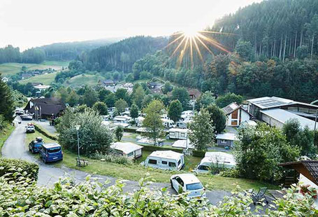 Terrassierter Campingplatz am Wald bei Sonnenuntergang 2026