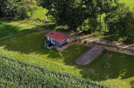 Tiny House mit rotem Dach auf einem Feld in der Lüneburger Heide 2025