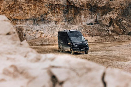 Allrad Wohnmobil in schwarz fährt in der Wüste 2025
