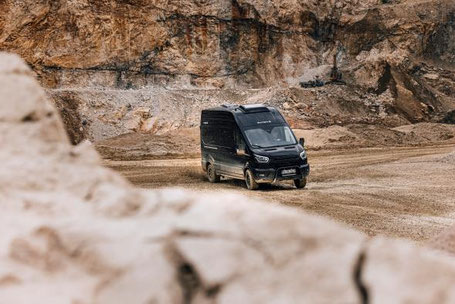 Allrad Wohnmobil in schwarz fährt in der Wüste 2026