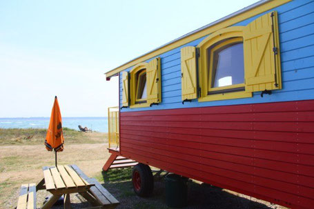 Bunter Zirkuswagen zum Übernachten am Strand 2026