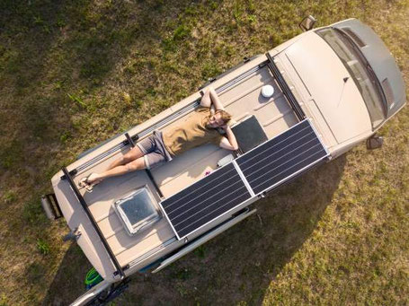 Mann schläft auf Dach von Wohnmobil Ansicht von oben 2026