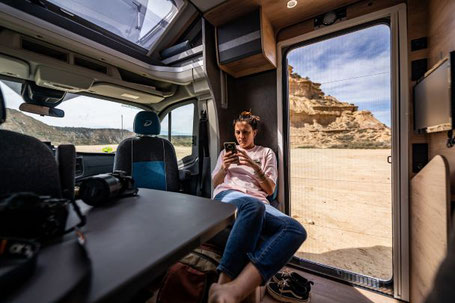 Dethleffs Just Go Wohnmobil Innenraum mit Frau am Handy 2025