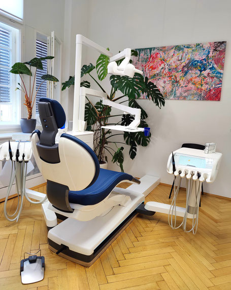Behandlungszimmer der Zahnarztpraxis Doumit in Berlin-Friedenau mit moderner Behandlungseinheit, blauem Polster und neuester Technik.