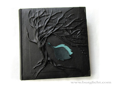 Fotoalbum Hardcover Hochrelief Baum, Bucheinbandmaterial Stoff schwarz, Blatt-Applikationen aus Echtleder hell- und dunkelgrün, Buchecken mattschwarz, 30cm x 30cm, 100 Seiten schwarz mit Pergamin