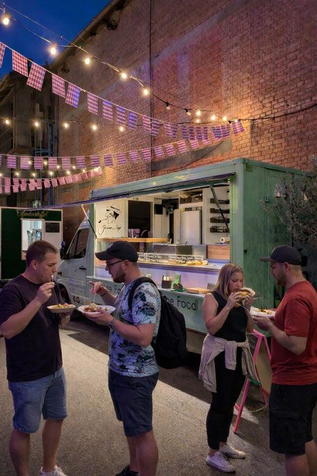 Gäste vor dem grünen Sepp Foodtruck während einer Firmen-Abend-Veranstaltung