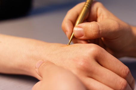 Ergotherapeutin behandelt Patientin am Handgelenk