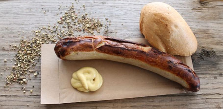 Bratwurst auf Holzbrett mit Senf und Brötchen
