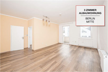 Heller Wohnraum einer verkauften 3-Zimmer-Altbauwohnung in Berlin-Mitte mit Holzboden und großen Fenstern