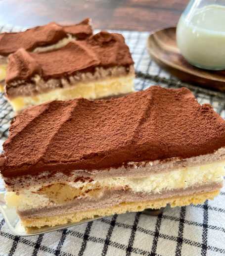 Drei Stück Birne-Mascarpone-Kuchen mit Kakaopulver bestäubt