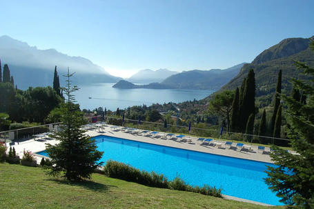 Appartement Ausblick von Casa di Giovanna auf den Gemeinschaftspool und den mit Bergen umgrenzenden Comer See bei Sonnenschein