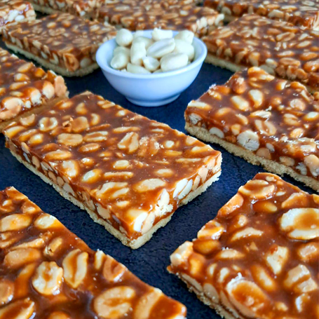 Drei Stück Apfel-Schmand-Kuchen auf einem Brett, daneben frische Äpfel