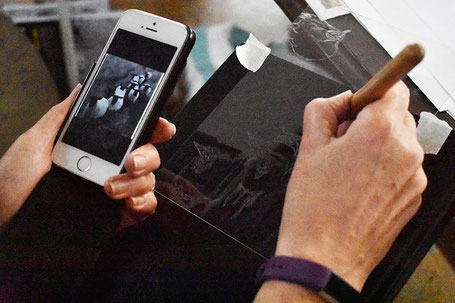 Scratching an image into the acrylic plate at a workshop