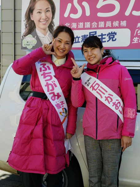 選挙事務所の外、街宣車の前でピースならぬ「石川L!」